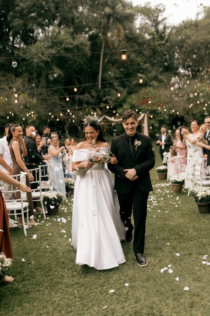 gallery-04 Happy couple walking down the aisle in an outdoor wedding ceremony.